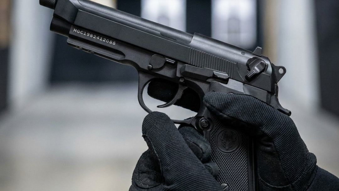 Shooter firing the HG198 Full Metal M92 GBB airsoft pistol at an indoor range