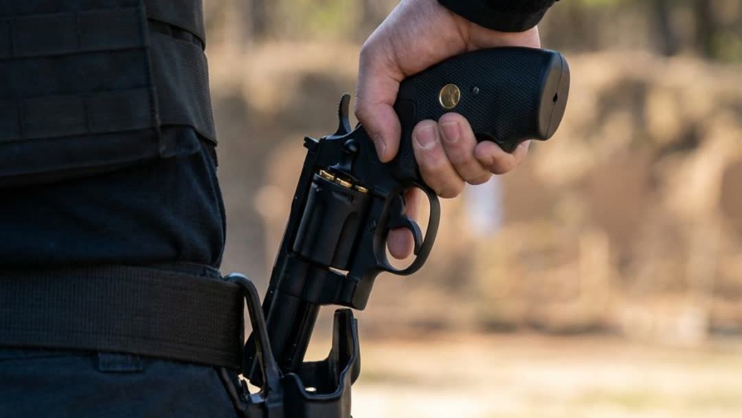 Player drawing the CO2 revolver from a holster at an outdoor range